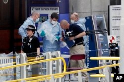 Forensic officers investigate the scene near the Manchester Arena, Manchester, England, May 23, 2017, the day after the suicide attack at an Ariana Grande concert that left 22 people dead.