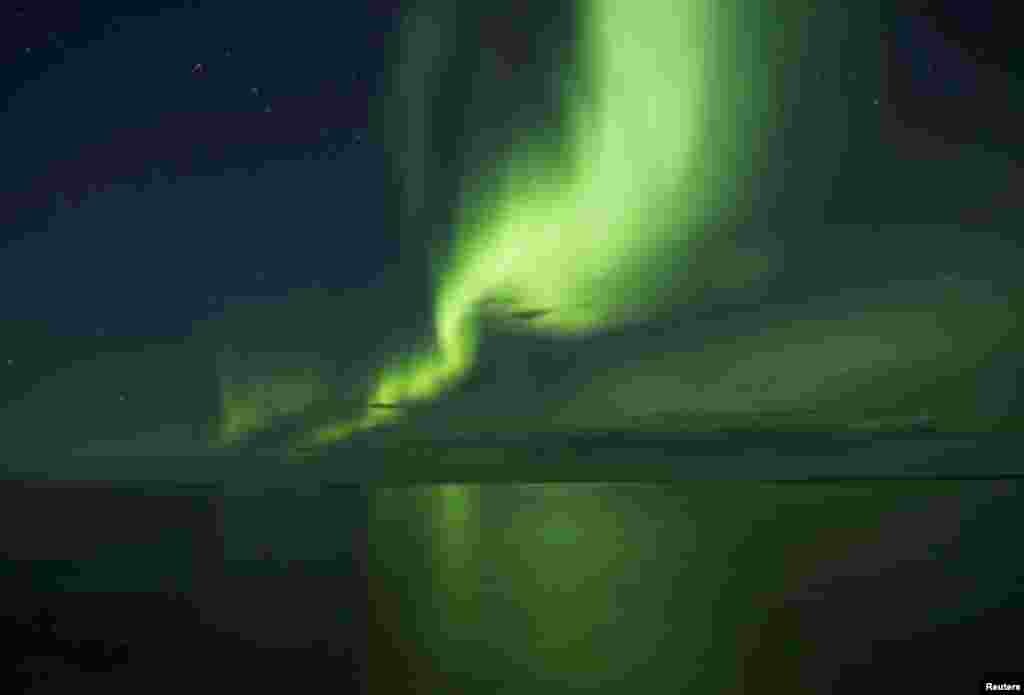 The aurora borealis appears over Great Bear Lake, the world&#39;s 8th largest lake in Deline, Northwest Territories, Canada.