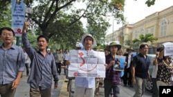 Protesters hold anti-China placards to protest what they say is aggressive action by China in the dispute over a resource-rich area in the South China Sea, while marching near the Chinese embassy in Hanoi, Vietnam, July 10, 2011