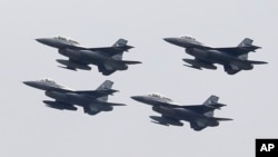 FILE - Pakistani Air Force F-16 fighter jets fly in formation during a military parade to mark Pakistan National Day, in Islamabad, Pakistan, March 23, 2019.