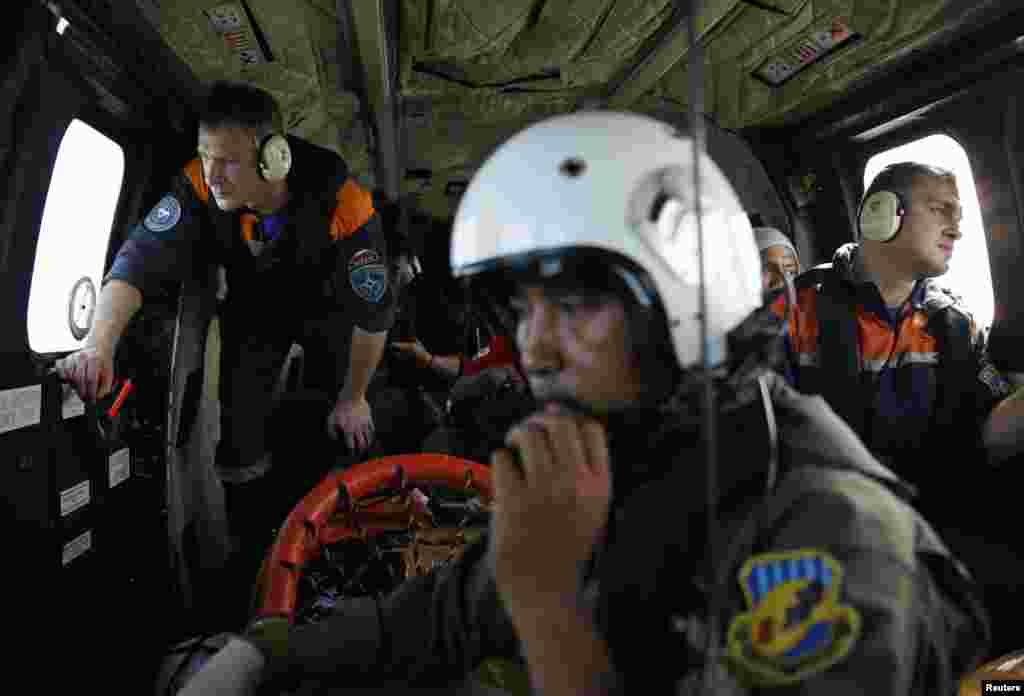 An Indonesian Air Force soldier (center) along with Russian search team members during a search operation for wreckage of the AirAsia Flight 8501, over the Java Sea, Jan. 7, 2015.