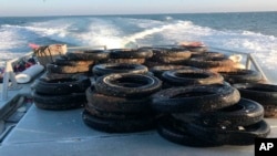 This Oct. 12, 2017, photo provided by the California Coastal Commission/UC Davis shows a pile of scrap tires after they were pulled out of the water off Balboa Peninsula in Newport Beach, Calif. 
