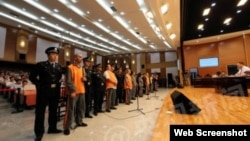 中國官方媒體公布的庭審照片中，嫌疑人站成一排，接受審判。（網絡圖片）