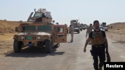 Military vehicles of Iraqi security forces are seen on a road during clashes with Islamic State (IS) militants in the Hamrin mountains in Diyala province, Sept. 20, 2014. 