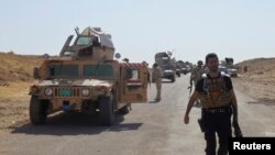 FILE - Military vehicles of Iraqi security forces on a road during clashes with Islamic State (IS) militants in the Hamrin mountains in Diyala province.