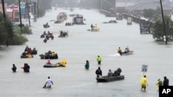 Rescue boats fill a flooded street as flood victims are evacuated during Tropical Storm Harvey in Houston, , Aug. 28, 2017.
