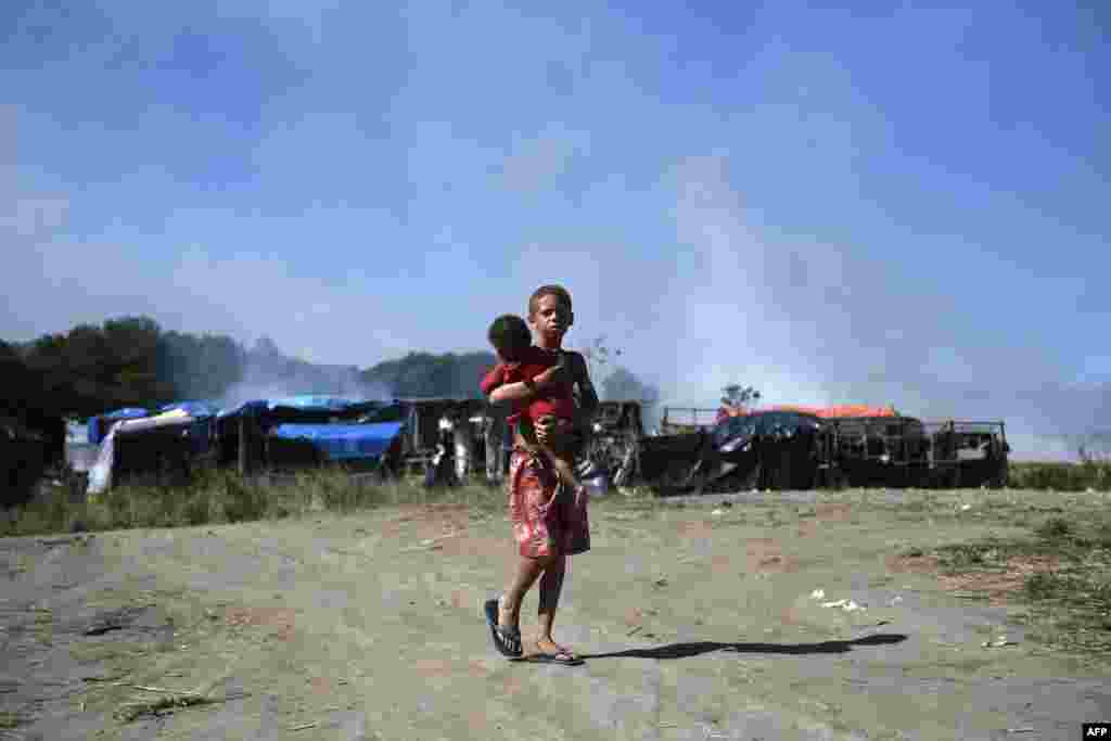 A boy and a baby are seen after the eviction of a settlement of homeless people set up during the Covid-19 pandemic in land owned by the Brazilian Oil Company Petrobras, in Itaguai, Rio de Janeiro state.
