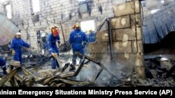 Emergency ministry employees search a site of a fire at Litchi, Kyiv, Ukraine.