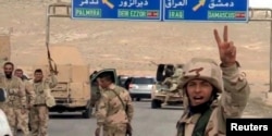 Forces loyal to Syria's President Bashar al-Assad gesture as they advance into the historic city of Palmyra in this picture provided by SANA, March 24, 2016.