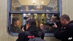 FILE - Musician Markus Rindt a 1989 German refugee is surrounded by media after boarding a train in Prague, Czech Republic, Oct. 1, 2009.