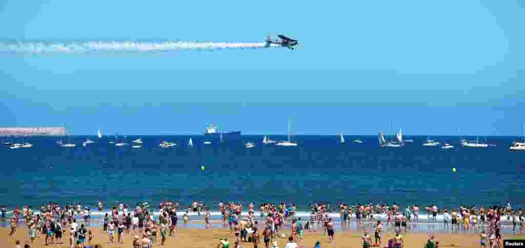 스페인 서북부 항구도시 히혼에서 진행된 항공박람회에 나선 &#39;세스나 L19&#39; 경비행기가 산 로렌초 해변 상공을 비행하고 있다.