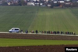 Imigran dikawal oleh polisi Jerman ke pusat pendaftaran, setelah melintasi perbatasan Austria-Jerman di Wegscheid dekat Passau, Jerman, 20 Oktober 2015. (REUTERS/Michael Dalder)