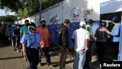 ARCHIVO - Una mujer policía pasa junto a personas que hacen cola para ingresar a una escuela utilizada como mesa de votación, para emitir su voto durante las elecciones presidenciales de Nicaragua en Managua, Nicaragua, el 7 de noviembre de 2021. REUTERS/Stringer
