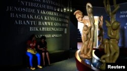 Rwandan people sit inside the Kigali Genocide Memorial Museum as the country prepares to commemorate the 20th anniversary of the 1994 genocide in the capital Kigali, April 5, 2014.