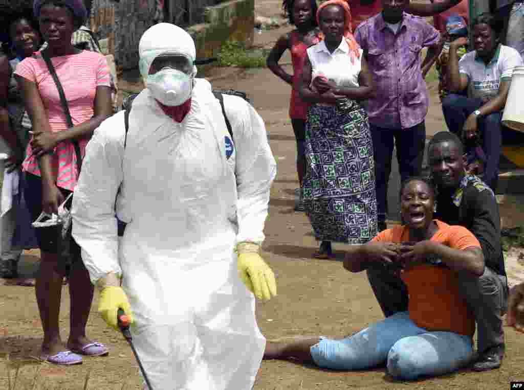 A woman reacts after her husband is suspected of dying from the Ebola virus, in the Liberian capital Monrovia, Oct. 4, 2014.