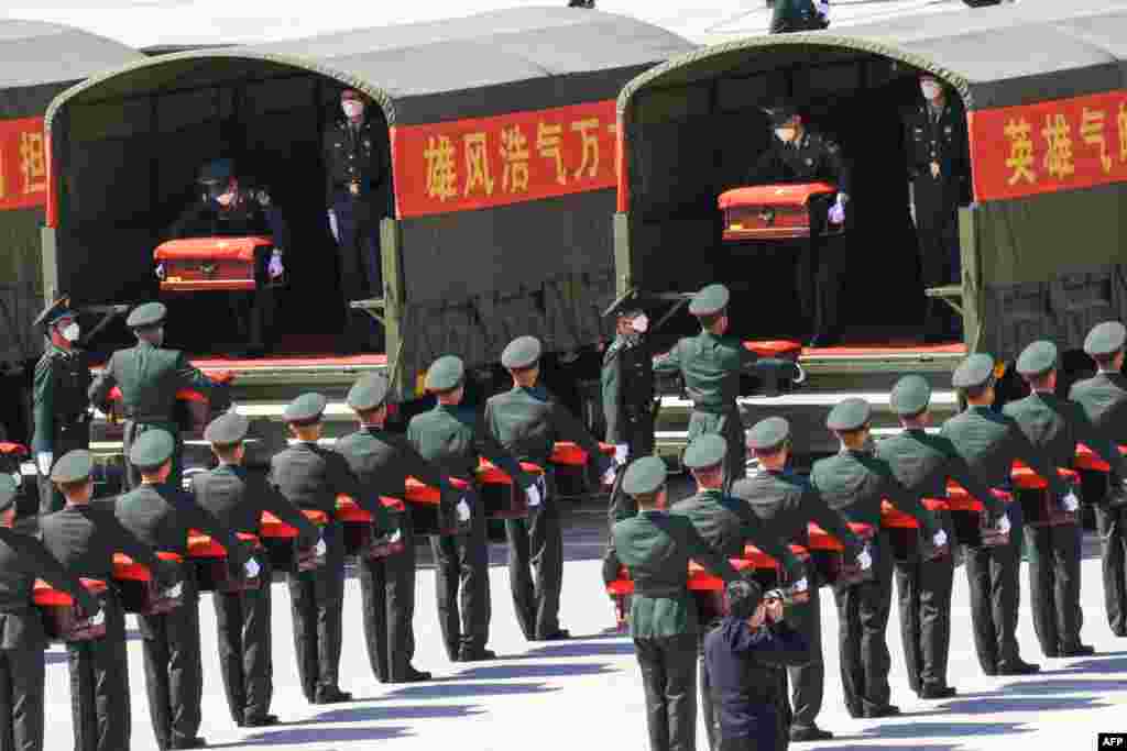 Chinese honor guards carry caskets containing the remains of Chinese soldiers killed during the 1950-53 Korean War at the Shenyang Taoxian International Airport in Shenyang in China&#39;s northeastern Liaoning province&nbsp;&nbsp;after the remains were returned from South Korea for permanent burial.