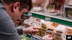Un trabajador de un supermercado en Bruselas retira alimentos expirados de los anaqueles. 16-1-17.