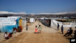 FILE - Refugees from Syria are seen outside their tents, in the town of Saadnayel, east Lebanon, April 23, 2019. Minority Yazidi refugees now face a possible forced return by Lebanese authorities to Syria.