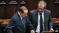 Italy's Prime Minister Silvio Berlusconi (L) talks with Interior Minister Roberto Maroni in Rome, October 14, 2011.