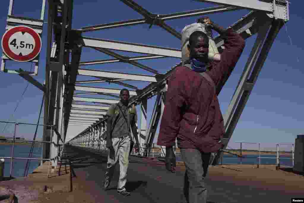 2013年1月18日，进驻马尔卡拉的法军控制了尼尔河上的一座大坝，行人走过战略位置重要的跨坝大桥。