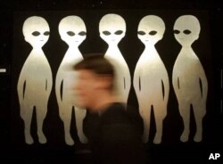 A patron passes a painting inside the International UFO Museum and Research Center in Roswell, N.M., Tuesday, June 10, 1997. The small town is bracing for its biggest invasion yet, the 50th anniverary of an alleged UFO crash. (AP Photo/Eric Draper)