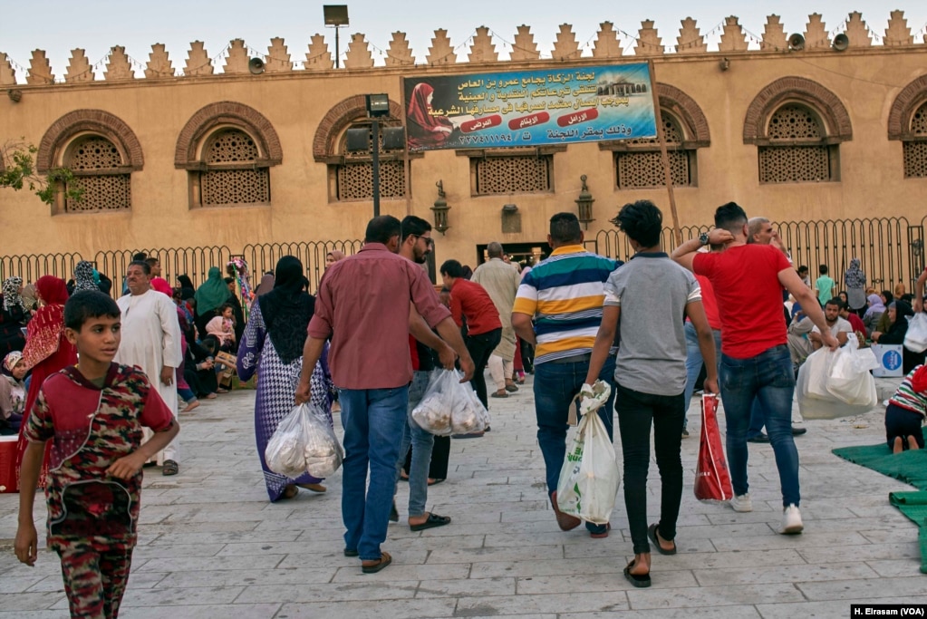 Muslims arrive before sunset to the mosque with food and drink to break their fast in old Cairo, Egypt, May 31, 2019. 