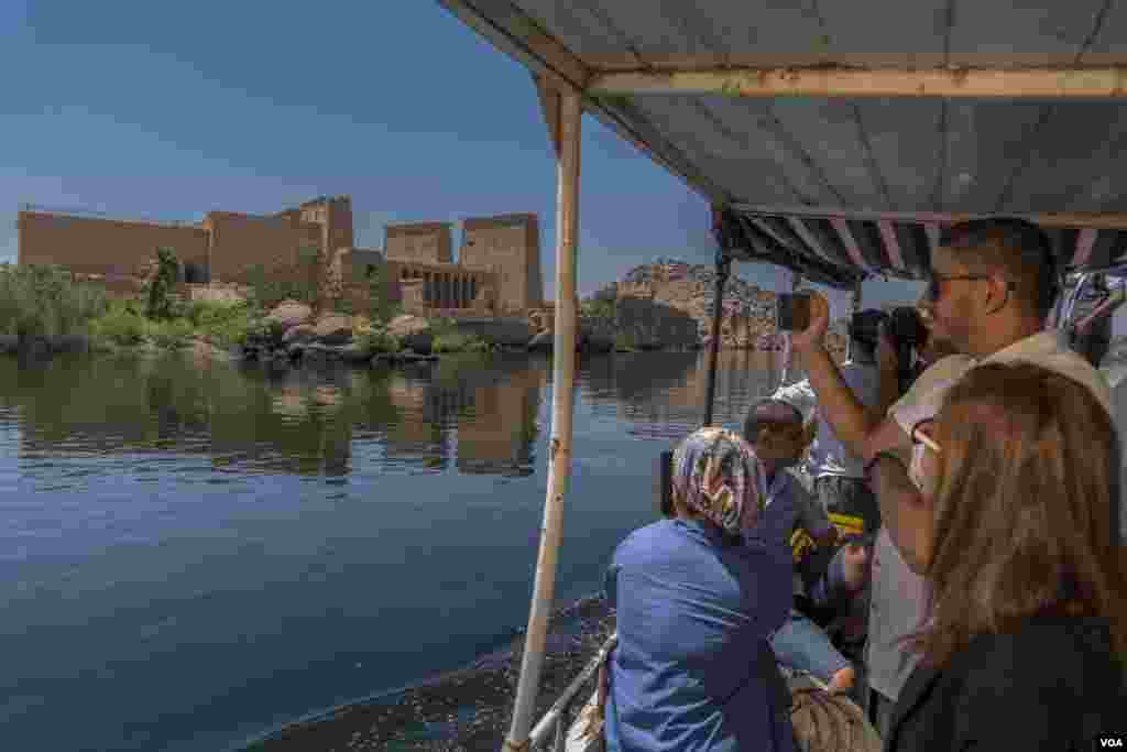 A tourist boat passes Philae Temple in Aswan, a city ravaged last month by a storm that damaged and destroyed homes and unleashed swarms of dangerous scorpions. Photo taken June 27, 2021 in Aswan, Egypt (Hamada Elrasam/ VOA)