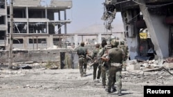 Soldiers loyal to Syria's President Bashar al-Assad are seen at an industrial area in the al-Kaboun neighborhood in Damascus after taking control of it from the Free Syrian Army, in this handout photograph distributed by Syria's national news agency SANA,