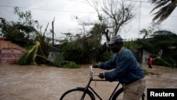 A man pushes a bicycle in a flood zone after Hurricane Matthew passed through Les Cayes, Haiti, Oct. 4, 2016. 