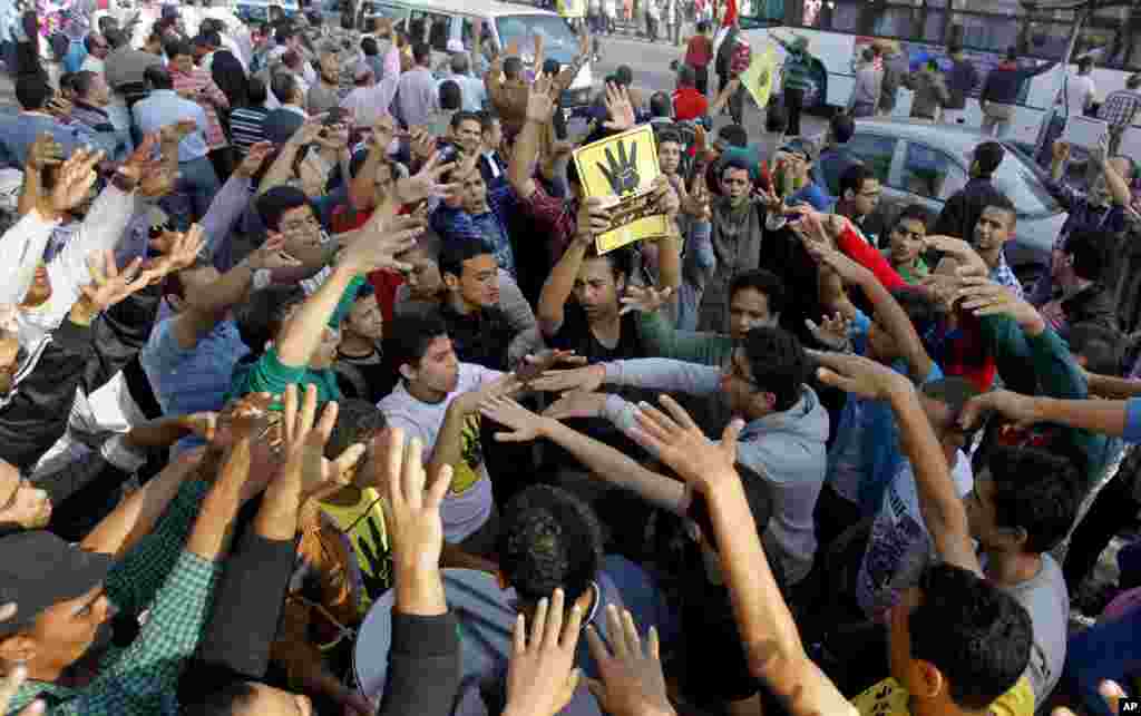 Supporters of Egypt's ousted President Mohammed Morsi raise their hands with four raised fingers, which has become a symbol of the Rabaah al-Adawiya mosque, where Morsi supporters held a sit-in for weeks that was violently dispersed in August, 2013.