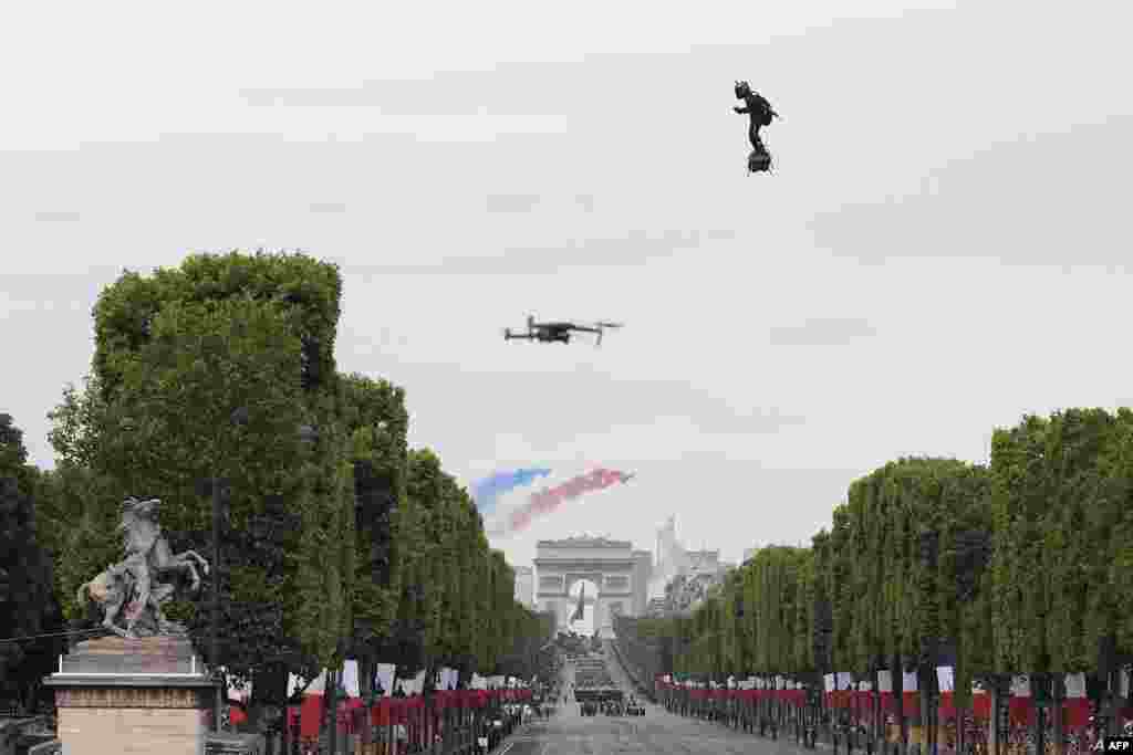 Zapata CEO Franky Zapata flies a jet-powered hoverboard or &quot;Flyboard&quot; as French elite acrobatic flying team &quot;Patrouille de France&quot; (PAF) flies over the Arc de Triomphe during the Bastille Day military parade down the Champs-Elysees avenue in Paris.