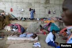 FILE - African migrants take shelter under the bridge of a motorway on the outskirts of Algiers, Algeria, June 28, 2017.