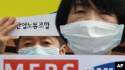 FILE - Members of Korea Health and Medical Workers' Union stage a rally to protest against the Samsung Medical Center's lack of control in preventing the spread of MERS (Middle East Respiratory Syndrome) in front of the center in Seoul, South Korea, June 19, 2015. 