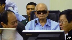 In this photo released by the Extraordinary Chambers in the Courts of Cambodia, Nuon Chea, center, who was the Khmer Rouge's chief ideologist and No. 2 leader, sits in the court room during a hearing at the U.N.-backed war crimes tribunal, in Phnom Penh, Oct. 17, 2014.