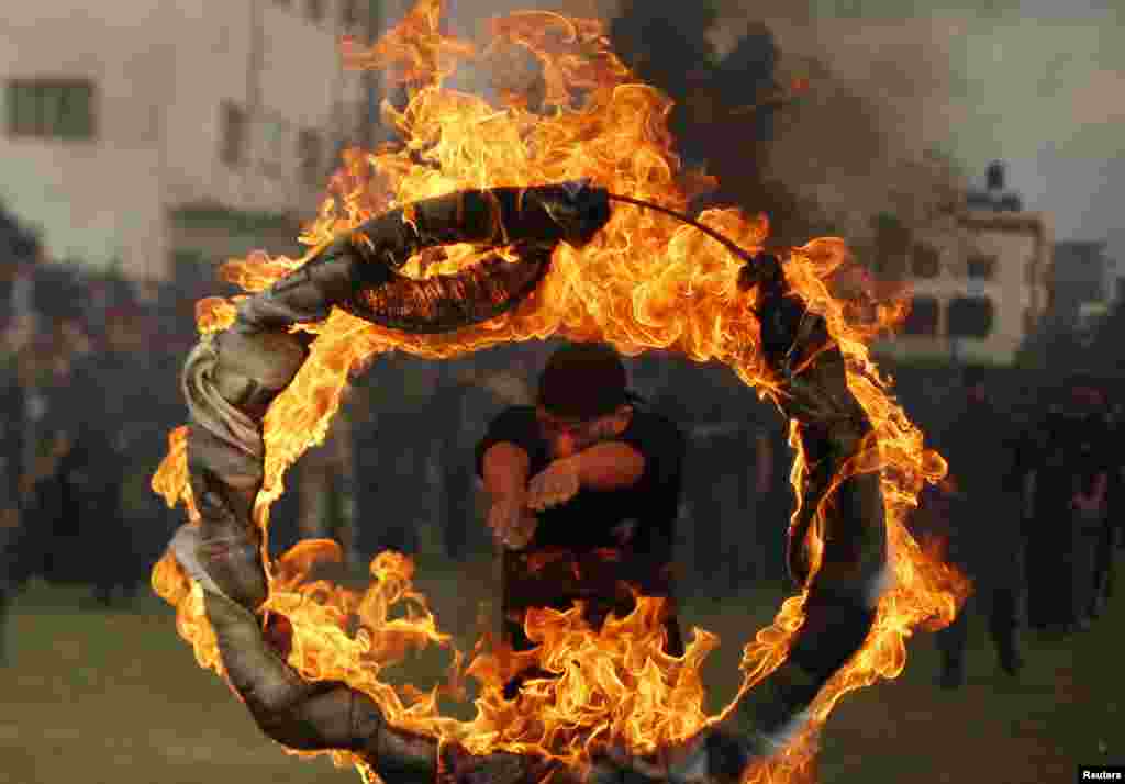 Seorang mahasiswa Palestina melompati lingkaran api dalam upacara wisuda program semi-militer di kota Gaza, Palestina. 