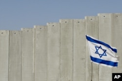 Bendera Israel berkibar di pinggiran Yerusalem, Rabu, 7 Juli 2004. (Foto: AP)