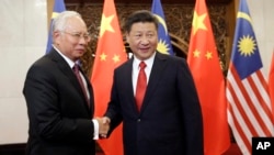 FILE - Malaysian Prime Minister Najib Razak, left, poses with Chinese President Xi Jinping for a photo prior to their meeting at Diaoyutai state guesthouse in Beijing, Nov. 3, 2016.