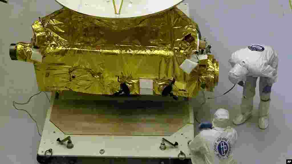Technicians work on the payload for the New Horizons mission to the planet Pluto.