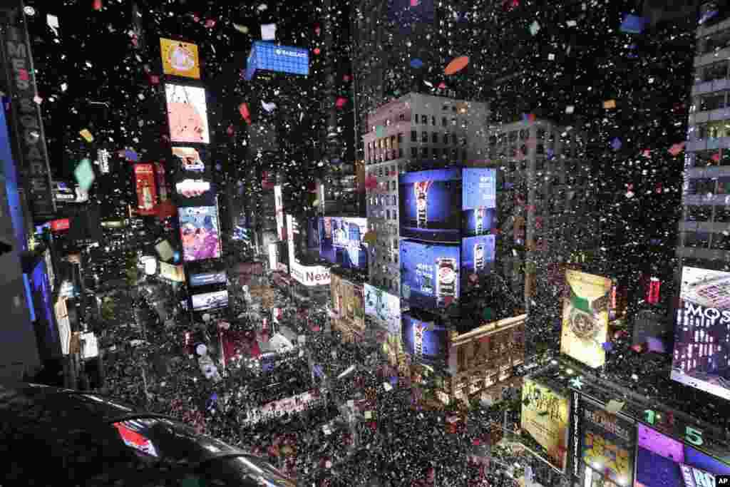 Confetti drops over the crowd as the clock strikes midnight during the New Year&#39;s celebration in Times Square as seen from the Marriott Marquis in New York, Jan. 1, 2018.