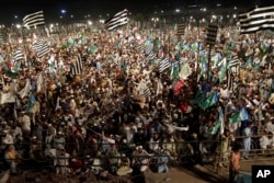 FILE - Supporters of a coalition of hard-line religious parties Mutahida Majlas-e-Amal or United Action Forum, listen to their leaders during a rally in Lahore, Pakistan, May 23, 2018, after the coalition launched their election campaign for upcoming parliamentary elections.