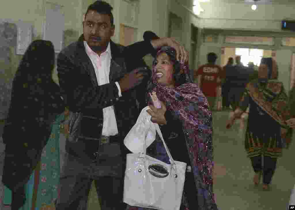 A man helps a woman injured in the suicide attack on a church, at a hospital in Quetta, Pakistan. Two suicide bombers attacked the church when hundreds of worshipers were attending services ahead of Christmas.