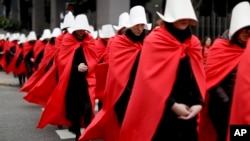 Mujeres en favor de una medida para expandir el aborto legal, vestidas con capas rojas y bonetes blancos como los personajes de la novela convertida en la serie de televisión "The Handmaid's Tale", marchan en silencio al Congreso, en Buenos Aires, Argentina.