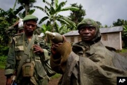 FILE - A Congolese government army soldier displays a mortar round after his unit returned from the frontline of fighting against rebel forces believed to be led by former warlord Bosco Ntaganda, in Kinyamahura, Congo.