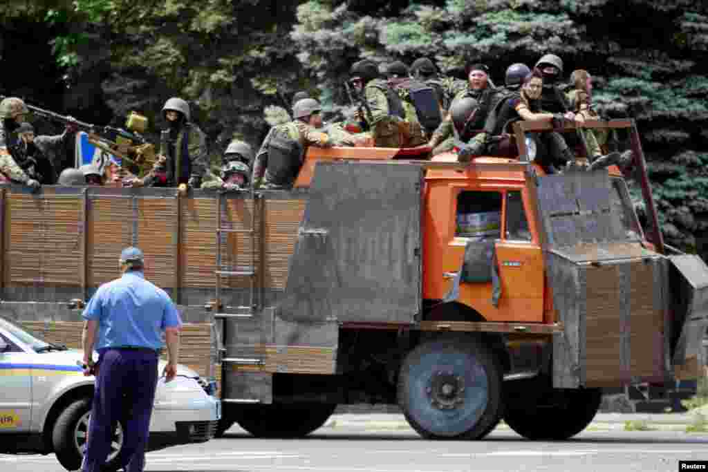 Ukrainian troops ride on the back of a truck near the site of fighting, Mariupol, June 13, 2014. 