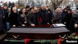 Relatives gather around the coffin of a victim of an explosion at a funeral in Volgograd, Dec. 31, 2013. 
