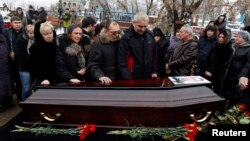 Relatives gather around the coffin of a victim of an explosion at a funeral in Volgograd, Dec. 31, 2013. 