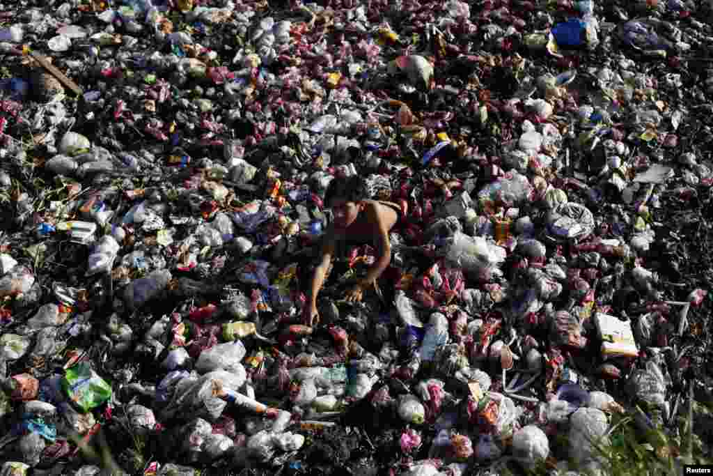 A boy collects plastic goods from a pile of garbage in the main sewerage area in Lahore, Pakistan.