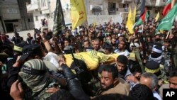 Familiares y militantes Fateh enmascarados cargan el cuerpo de Hamdan Abu Amsha, un joven de 23 años, muerto el viernes en los enfrentamientos en Gaza entre palestinos y fuerzas israelíes, que el secretario general de la ONU Antonio Guterres ha pedido sean investigados. Marzo 31 de 2018.