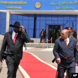 Sudanese President Omar al-Beshir (R) walks with Sudan's First Vice President and south Sudan leader Salva Kiir at the airport in Khartoum, as he prepares to leave for Chad, 21 Jul 2010