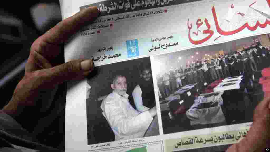 An Egyptian holds Al-Ahram newspaper with a picture of the arrested leader of the Muslim Brotherhood, Cairo, August 20, 2013.